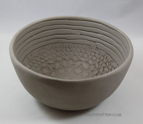Hand-built serving bowl made on classic mid-size plaster hump mold with textured clay slabs and coils in white stoneware. Clay is in the greenware state. (Sample)